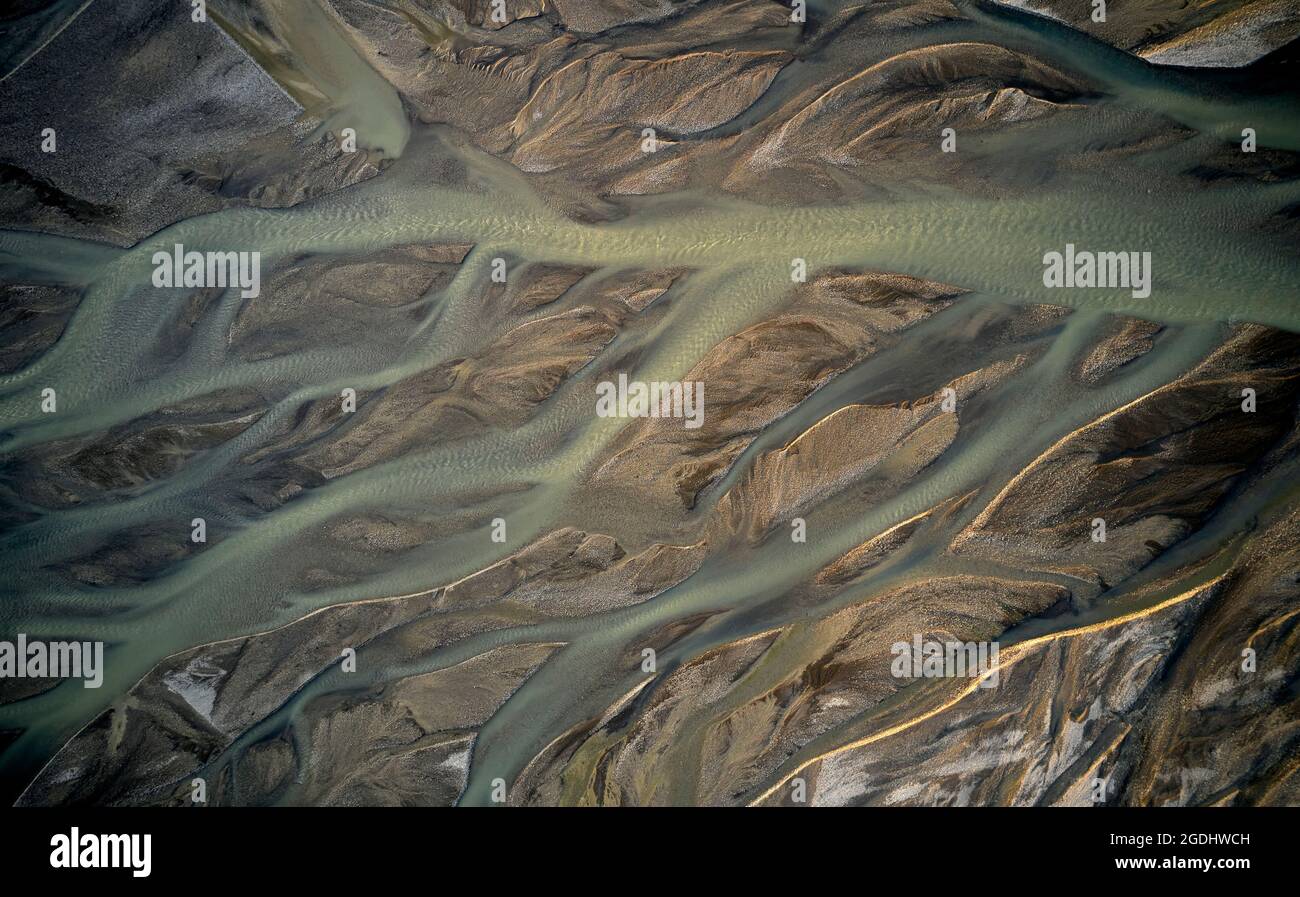 Luftaufnahme eines Baches aus sauberem Wasser mit vielen Ästen, die durch unwegsames Gelände in Island fließen Stockfoto