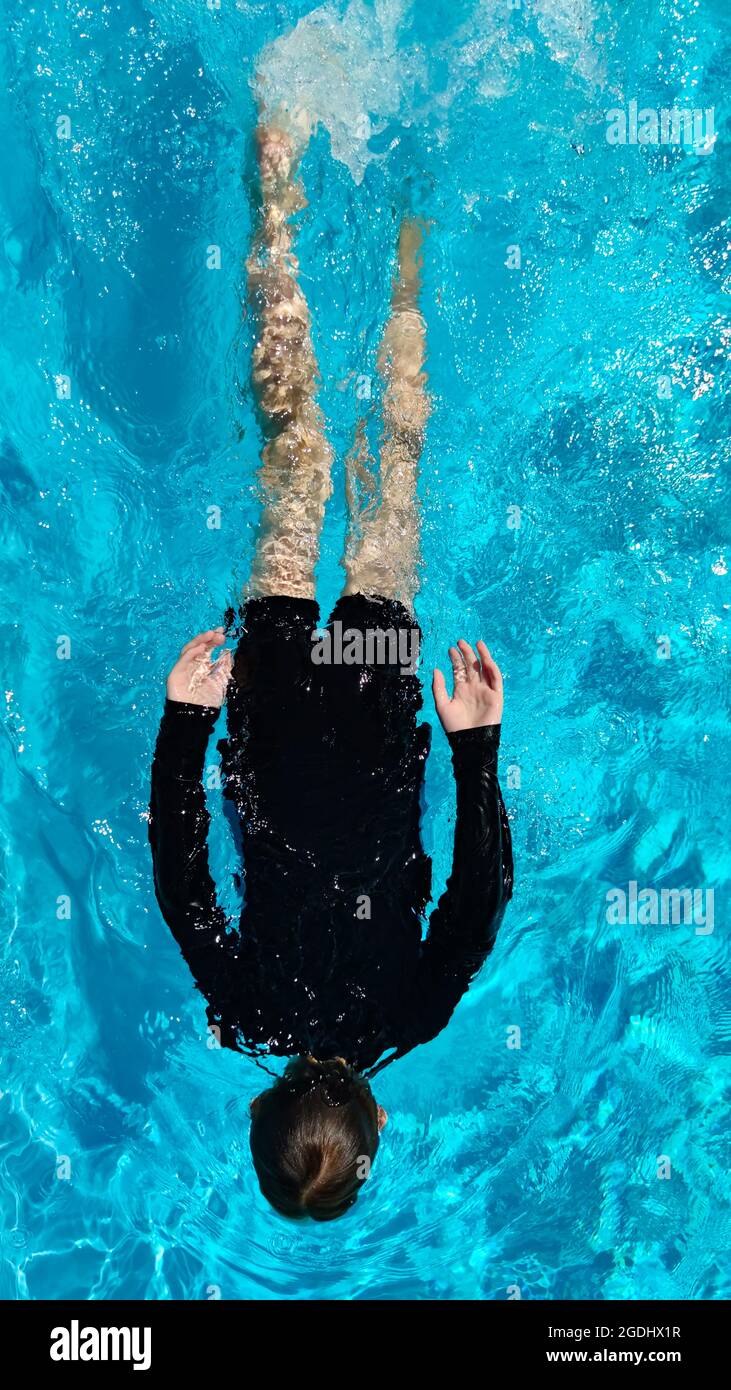 Rückansicht auf den Jungen, der im Pool schwimmt, flach liegend, Seychellen Stockfoto