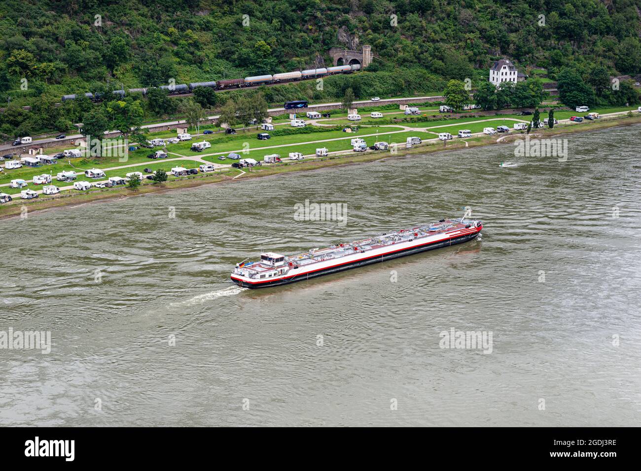 Ein Tankerschiff segelt auf dem Rhein in Westdeutschland, sichtbare Gebäude und Karawanen am Flussufer, Luftaufnahme. Stockfoto