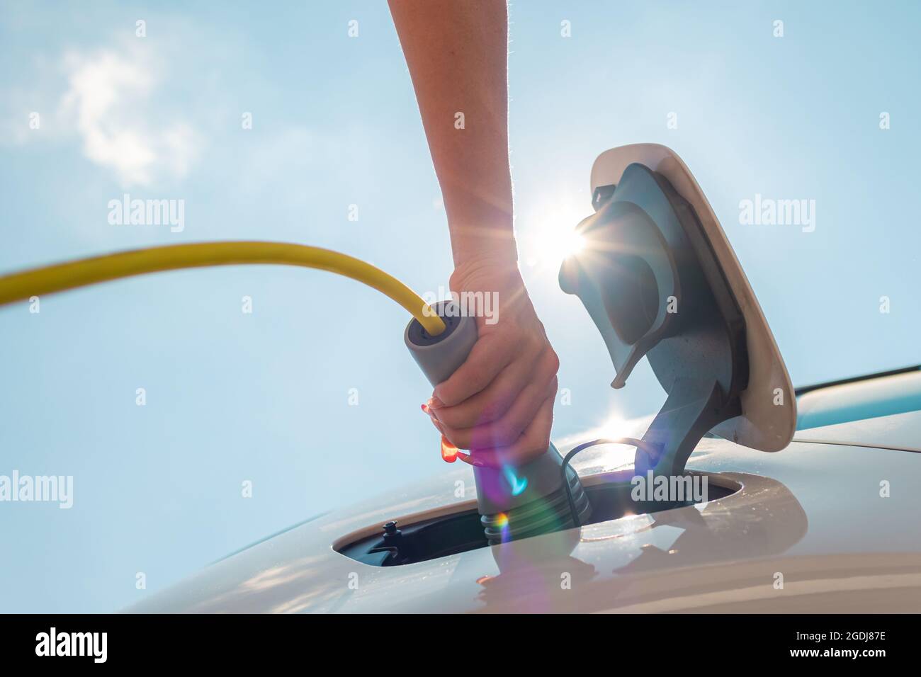 Weibliche Hände, die ein Ladegerät in die Steckdose stecken Stockfoto
