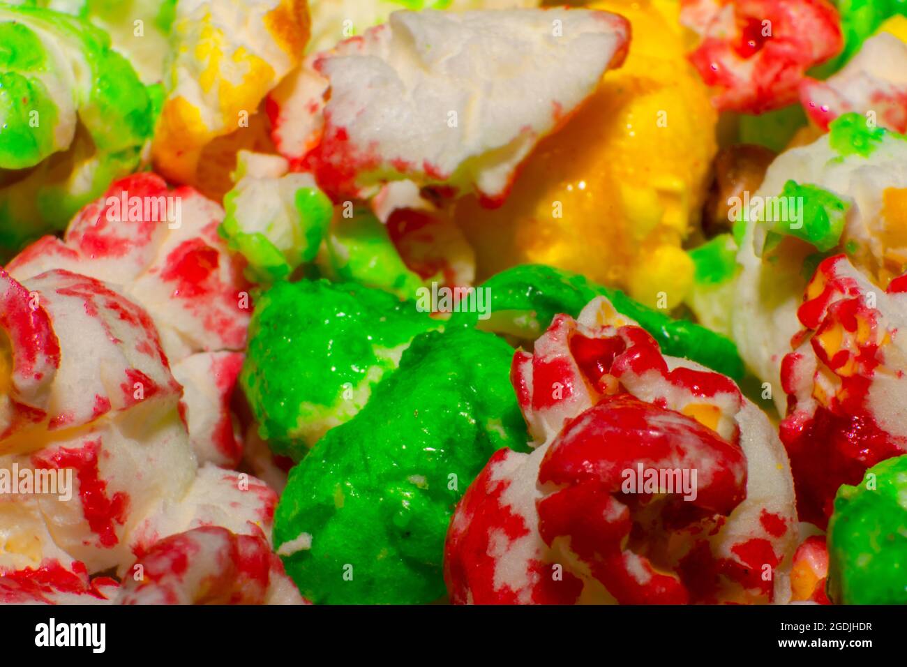 Farblich gefärbte süße Popcorne mit grünem Gelb und Rot. Filme und Partyessen für Kinder. Pipocas coloridas. Stockfoto