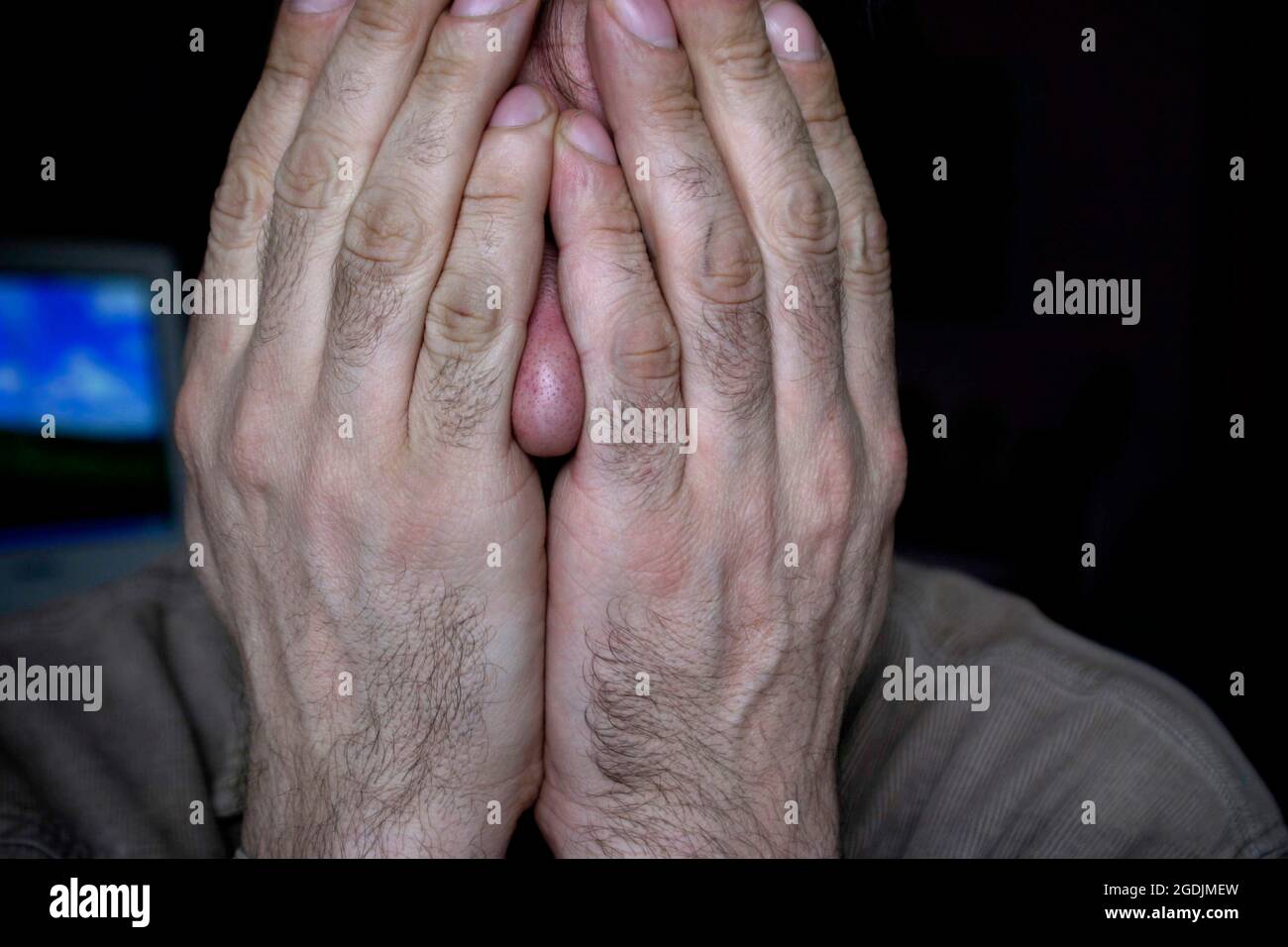 Mann, der seine Hände vor sein Gesicht hält, Österreich Stockfoto