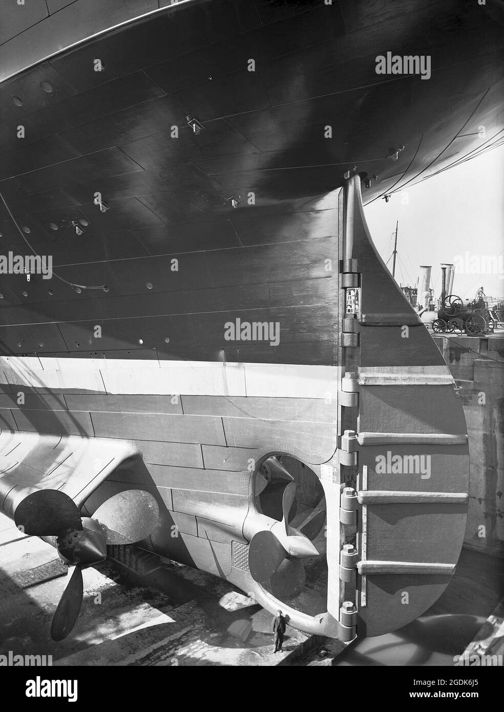 Die Olympischen Spiele in ihrem Hardland & Wolff Trockendock in Belfast. Eine menschliche Figur zeigt, wie groß das Ruder und die Propeller sind. Stockfoto