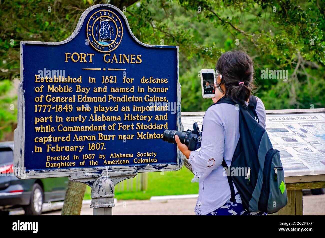 Ein Tourist verwendet Apple FaceTime, um eine Freundin zu videospielen und ihre Sicht auf den historischen Marker von Fort Gaines am 12. August 2021 in Dauphin Island, Alabama, zu teilen. Stockfoto