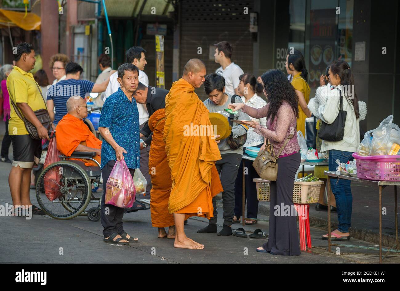 BANGKOK, THAILAND - 02. JAN 2019: Buddhistische Mönche sammeln Opfergaben auf einer Stadtstraße Stockfoto