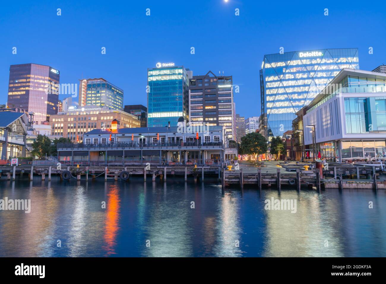 Wellington Neuseeland   Juli 28 2021;Skyline von Wellington bei Nacht vom Kai mit Stadtlichtern, Schildern und Reflexionen auf dem Abrour. Stockfoto