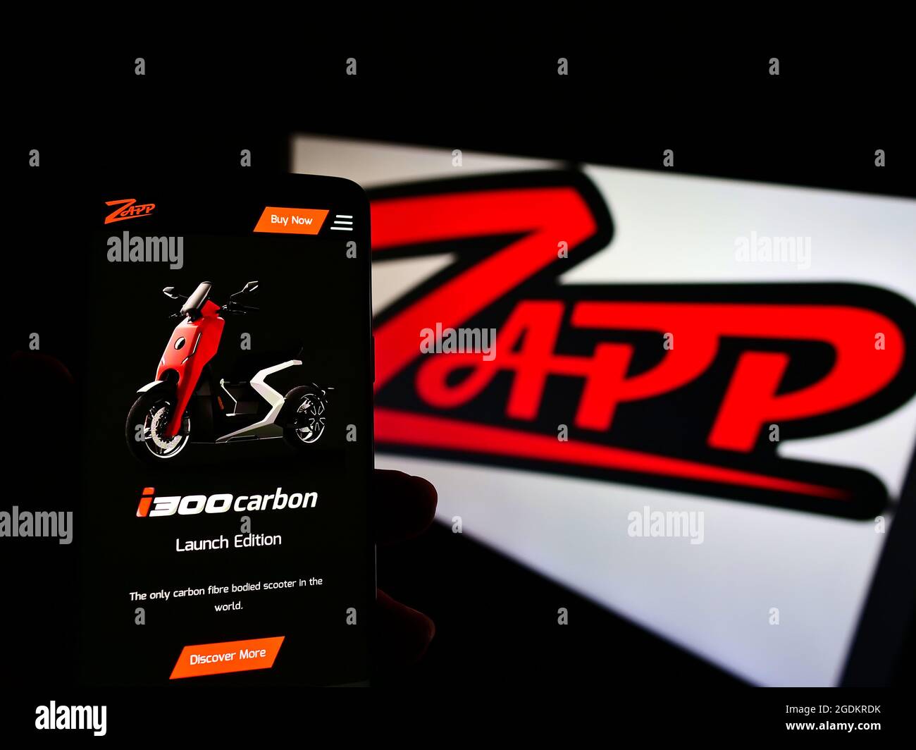 Person, die Smartphone mit Website der Elektromotorrad Firma Zapp Roller auf dem Bildschirm vor dem Logo hält. Konzentrieren Sie sich auf die Mitte des Telefondisplays. Stockfoto