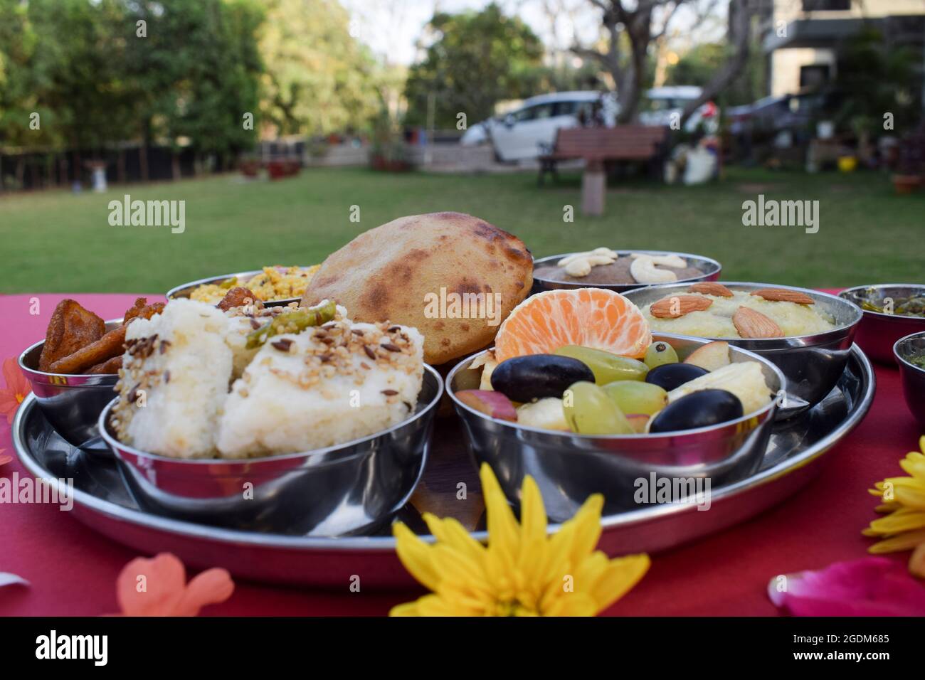 Komplette indische Fastfood-Mahlzeiten, die während des Sawan mahina- oder Saawan-Monats auf einer Thali-Platte serviert werden, wobei alle Upawas-Speisen in einem Buffet mit gemischtem Obst im Freien serviert werden Stockfoto