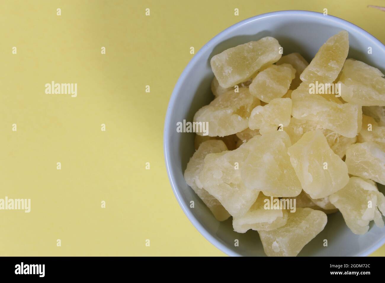 Frische und getrocknete Bio-Ananas auf gelbem Hintergrund Closeup Stockfoto