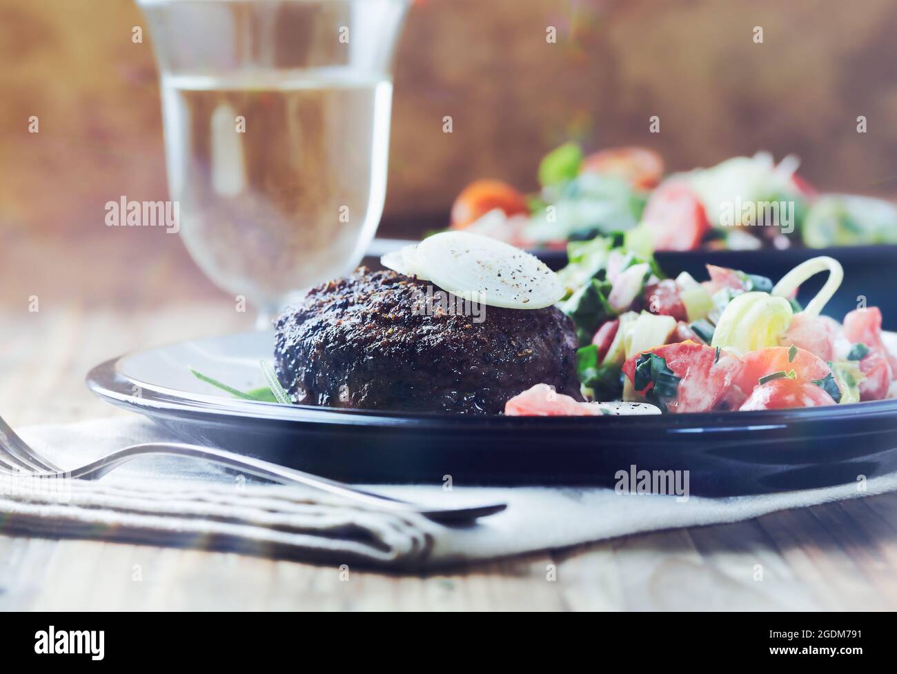 Gebratenes Hamburger-Steak mit frischem Salat. Holzhintergrund. Nahaufnahme. Stockfoto
