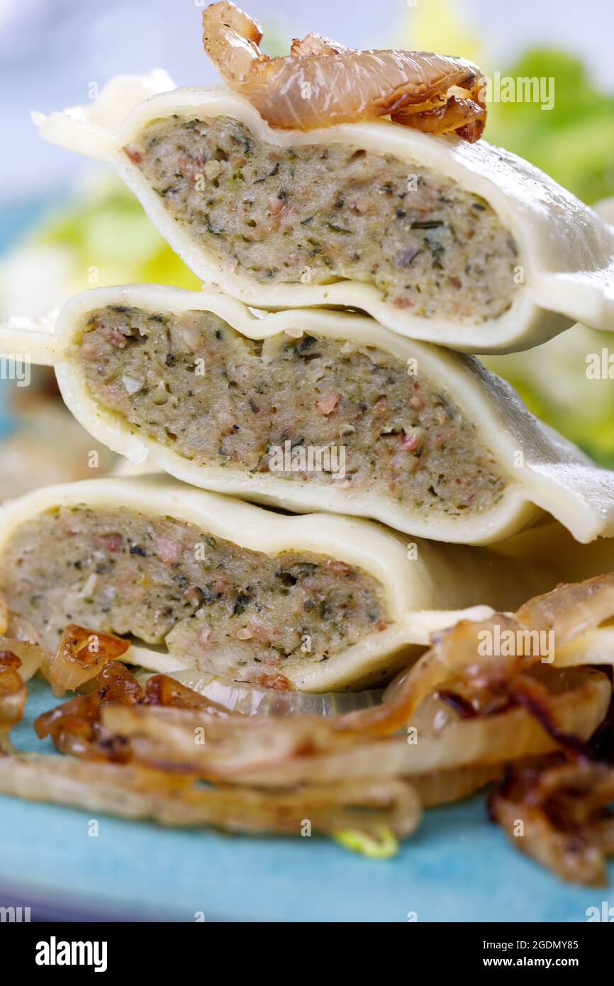 Hälften schwäbische maultaschen Pasta mit Salat Stockfoto
