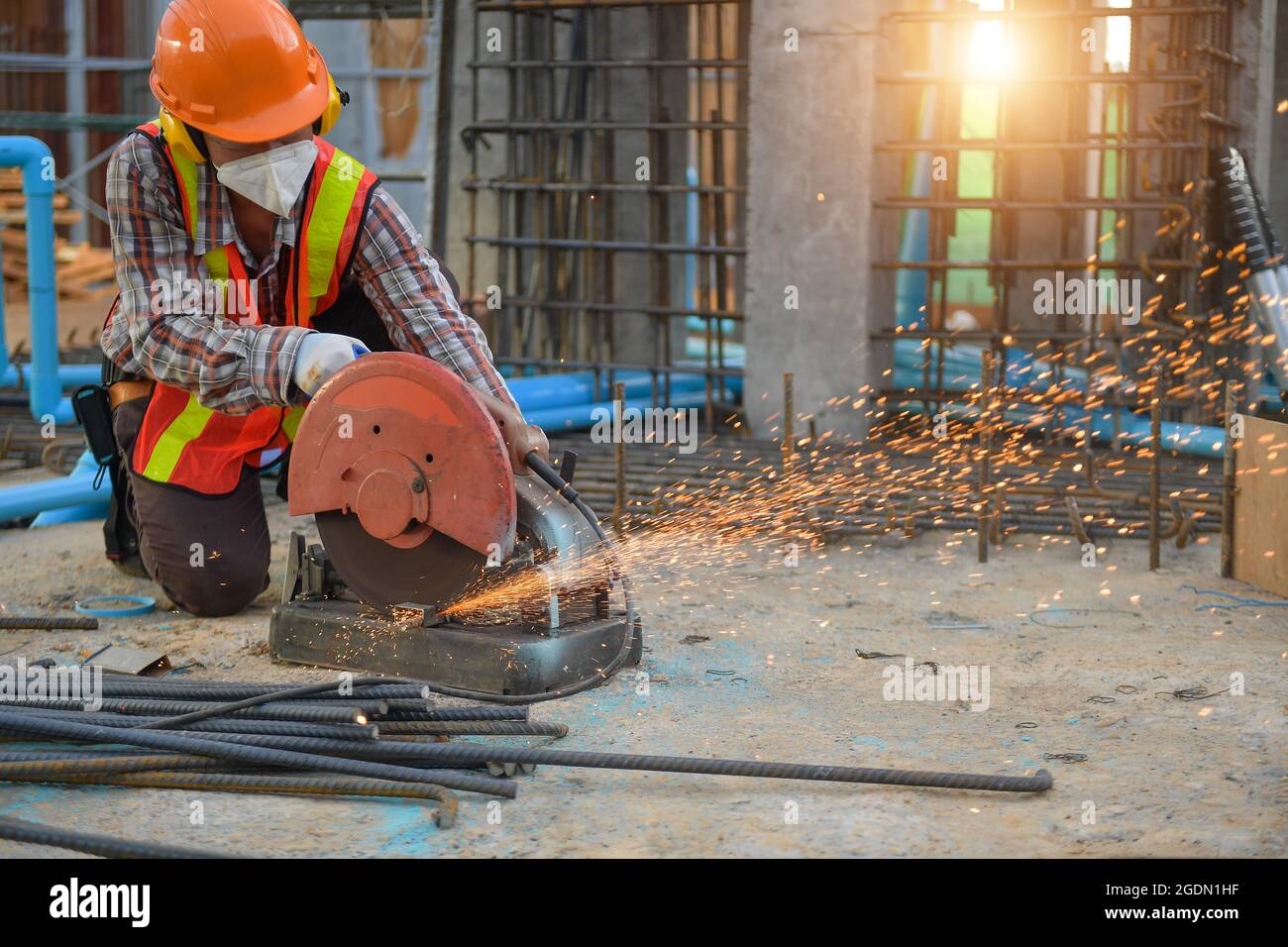Der Arbeiter schneidet Stahl mit einer Trennscheibe der Schneidmaschine ab, bis beim Schneiden von Stahl Funken entstehen. Stockfoto