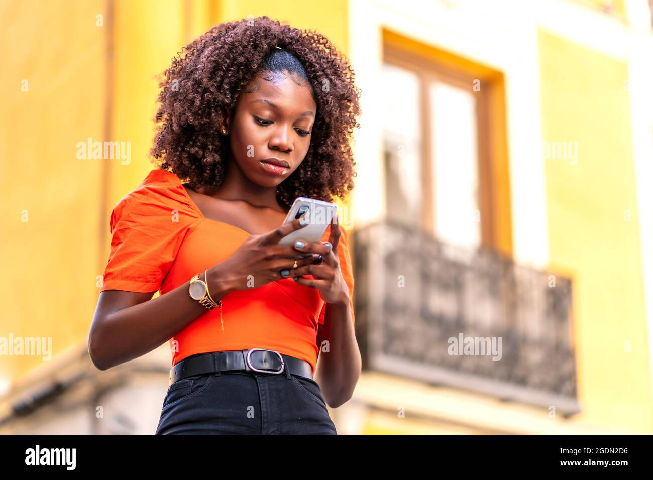 Junge afro Haar Mädchen mit ihrem Smartphone Stockfoto