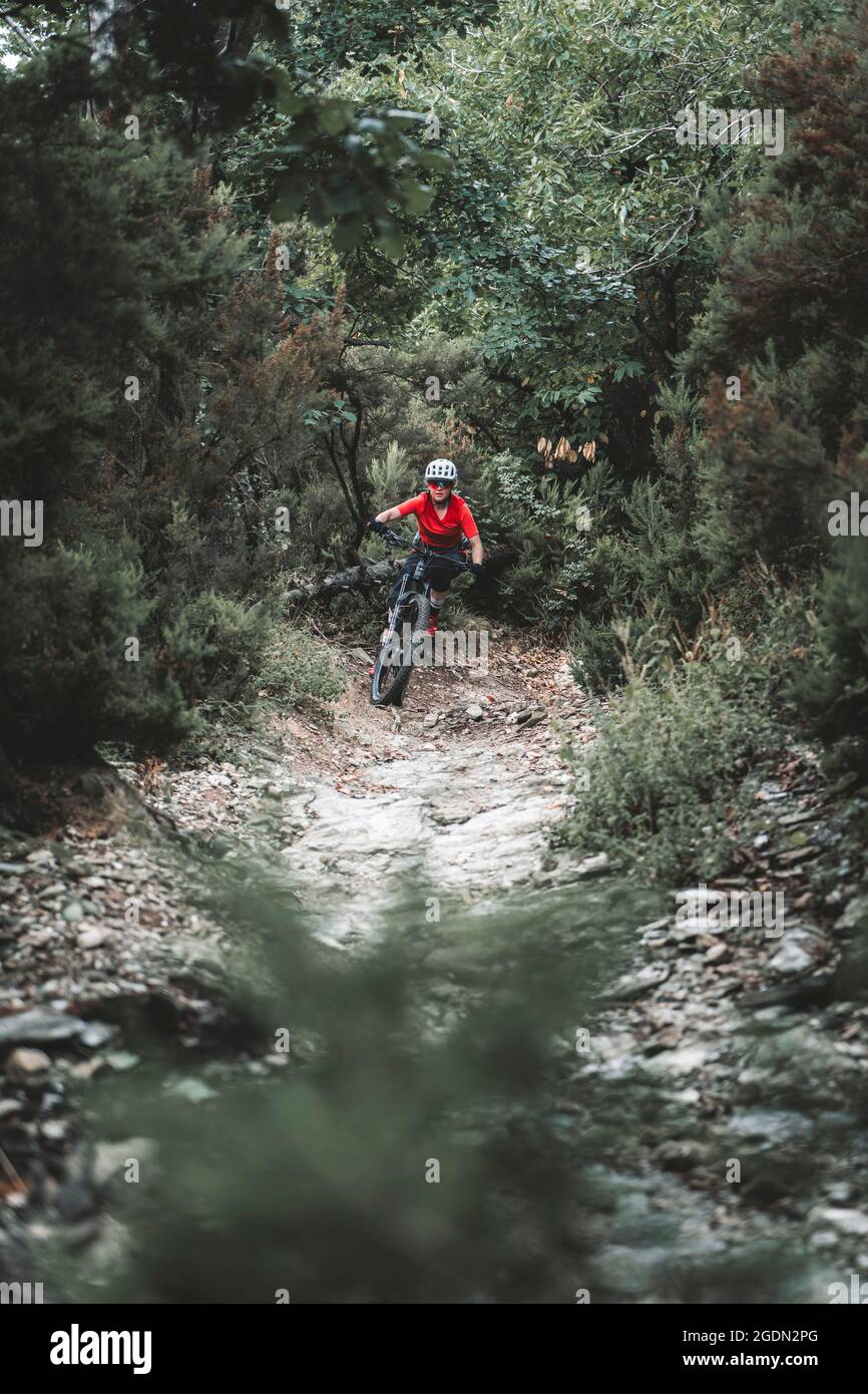 Mittellange Nahaufnahme einer weiblichen Mountainbikerin auf einem felsigen Trail Stockfoto