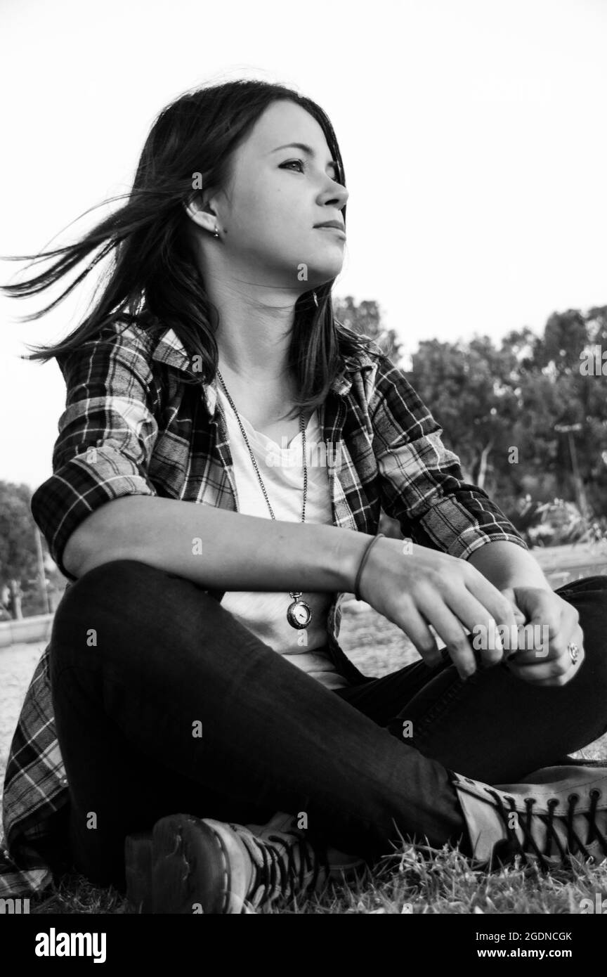 moody Bild einer jungen 25-jährigen Frau allein in einem Park Stockfoto