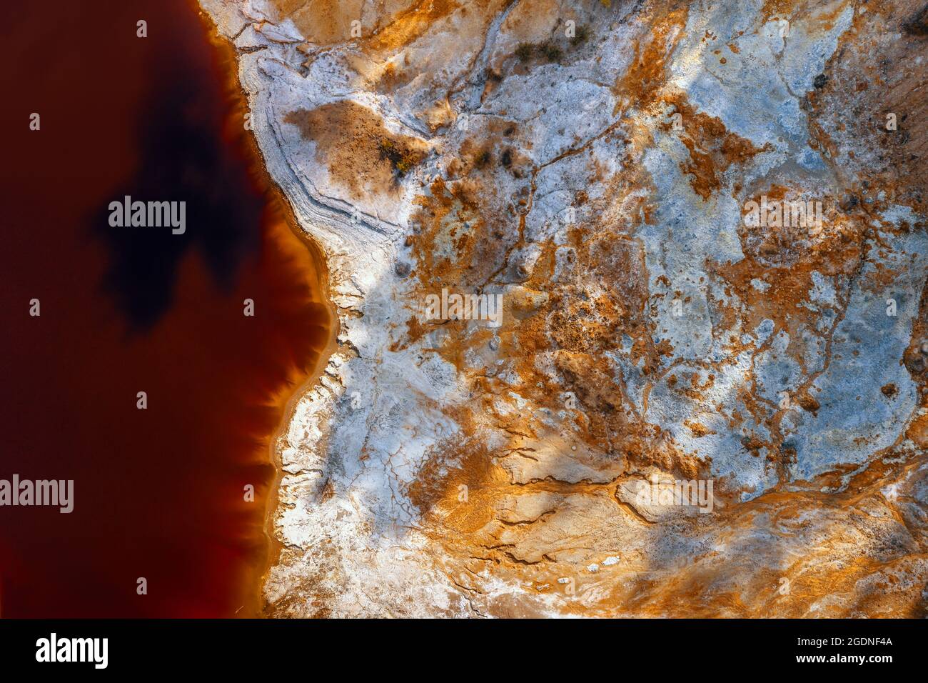 Ufer bedeckt mit Chemikalien und rotem Wasser von saurem Minensee bei verlassenen Tagebau-Kupfermine, Luftaufnahme direkt darüber Stockfoto