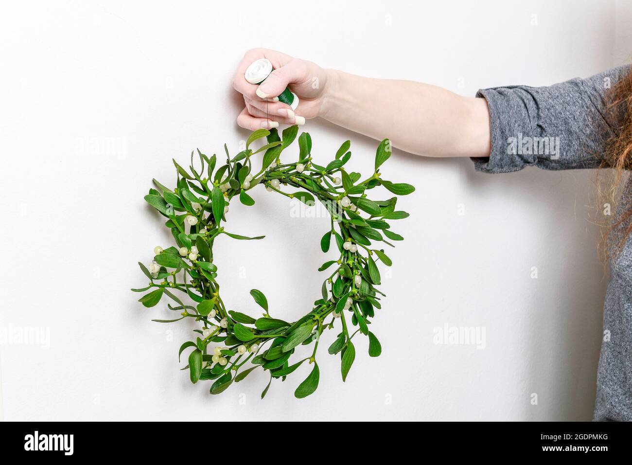 Florist bei der Arbeit: Wie man Misteltürkranz macht, Schritt für Schritt, Tutorial. Stockfoto