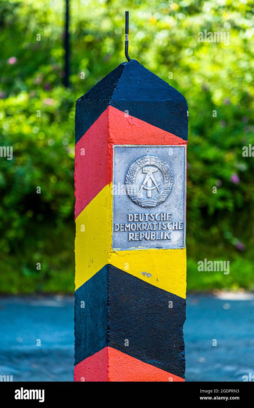 Schwarz-rot-goldener Grenzposten am Eisernen Vorhang mit Plakette: DEMOKRATISCHE REPUBLIK DEUTSCHLAND bei Sorge Stockfoto
