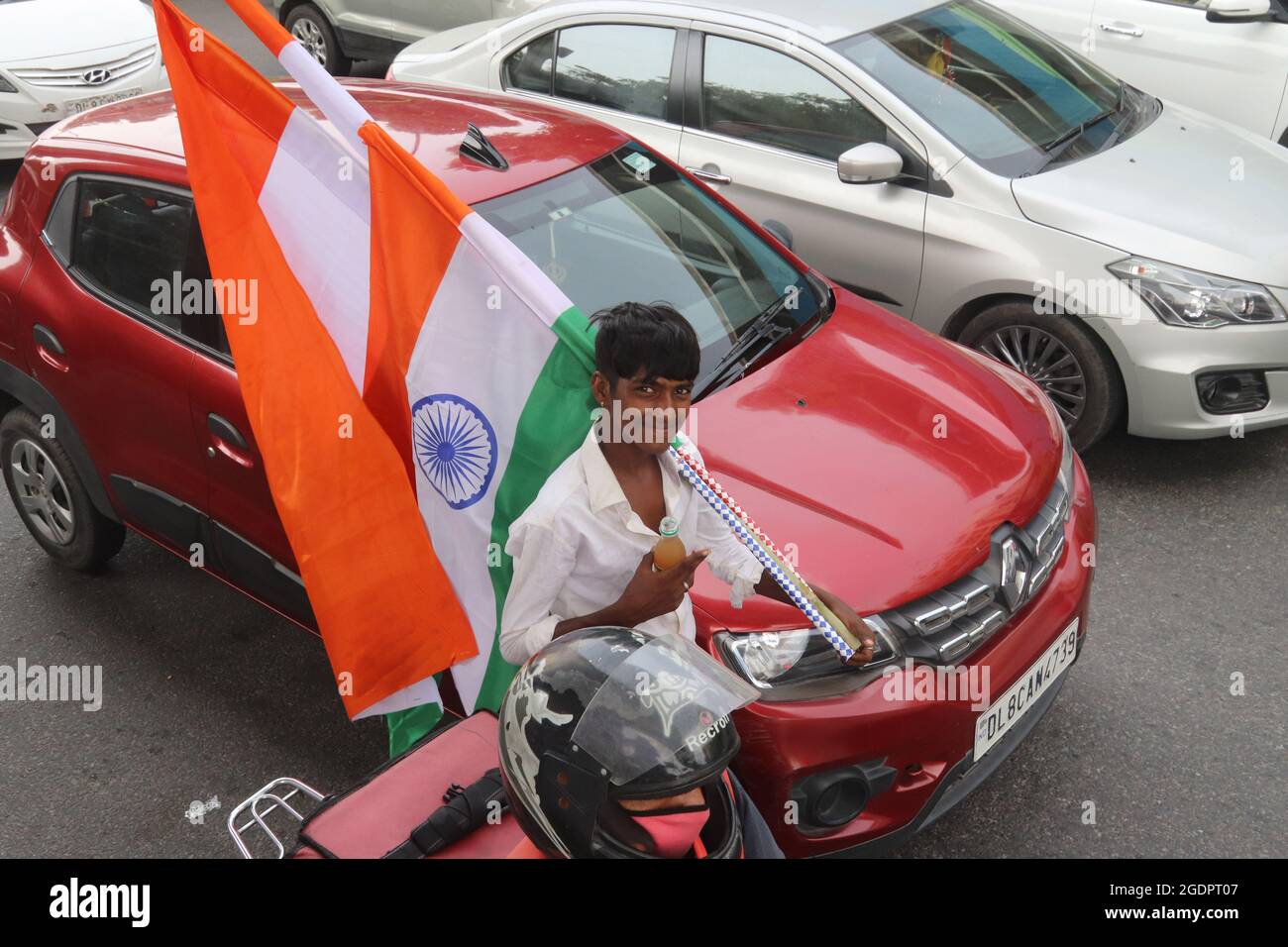 Neu-Delhi, Indien. August 2021. Ein Straßenhändler verkauft indische Nationalflaggen am Straßenrand vor den Feierlichkeiten zum 75. Indischen Unabhängigkeitstag.der indische Premierminister Narendra Modi wird am 15. August (Sonntag) von den Wällen des historischen Roten Forts aus das Land ansprechen, um die 75 Jahre Unabhängigkeit zu feiern. Kredit: SOPA Images Limited/Alamy Live Nachrichten Stockfoto