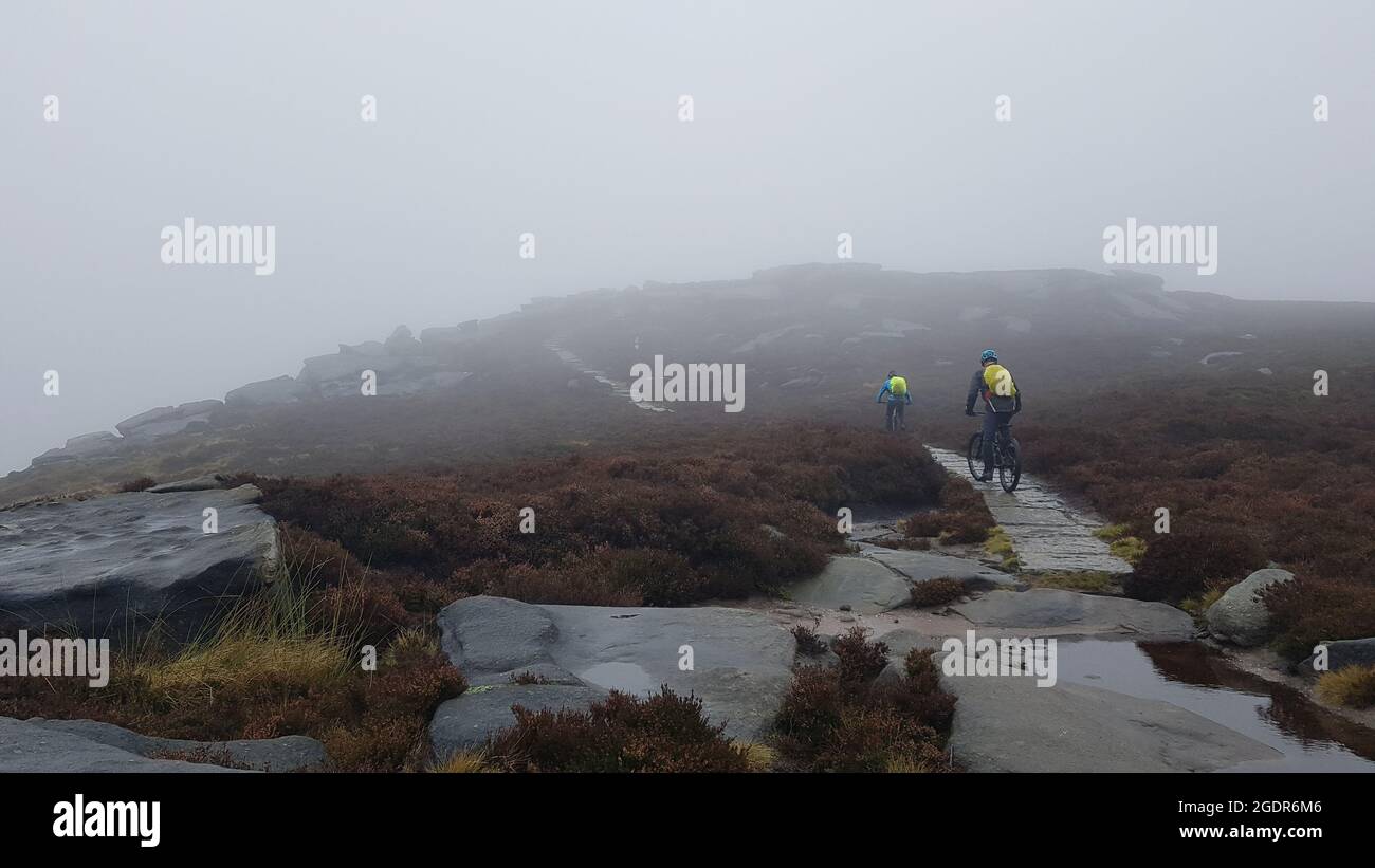 Mountainbiker fahren über die Moorlandschaft von Bamford Edge über dem Ladybower Reservoir, dem Peak District National Park Stockfoto