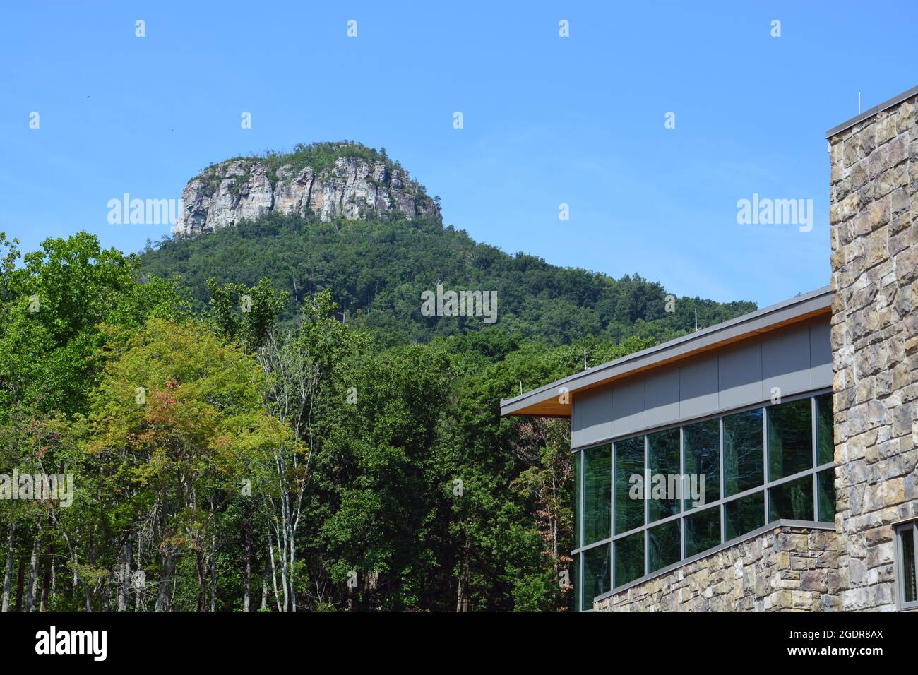 Die charakteristische Spitze des Pilot Mountain erhebt sich über dem neuen Besucherzentrum des Parks. Stockfoto