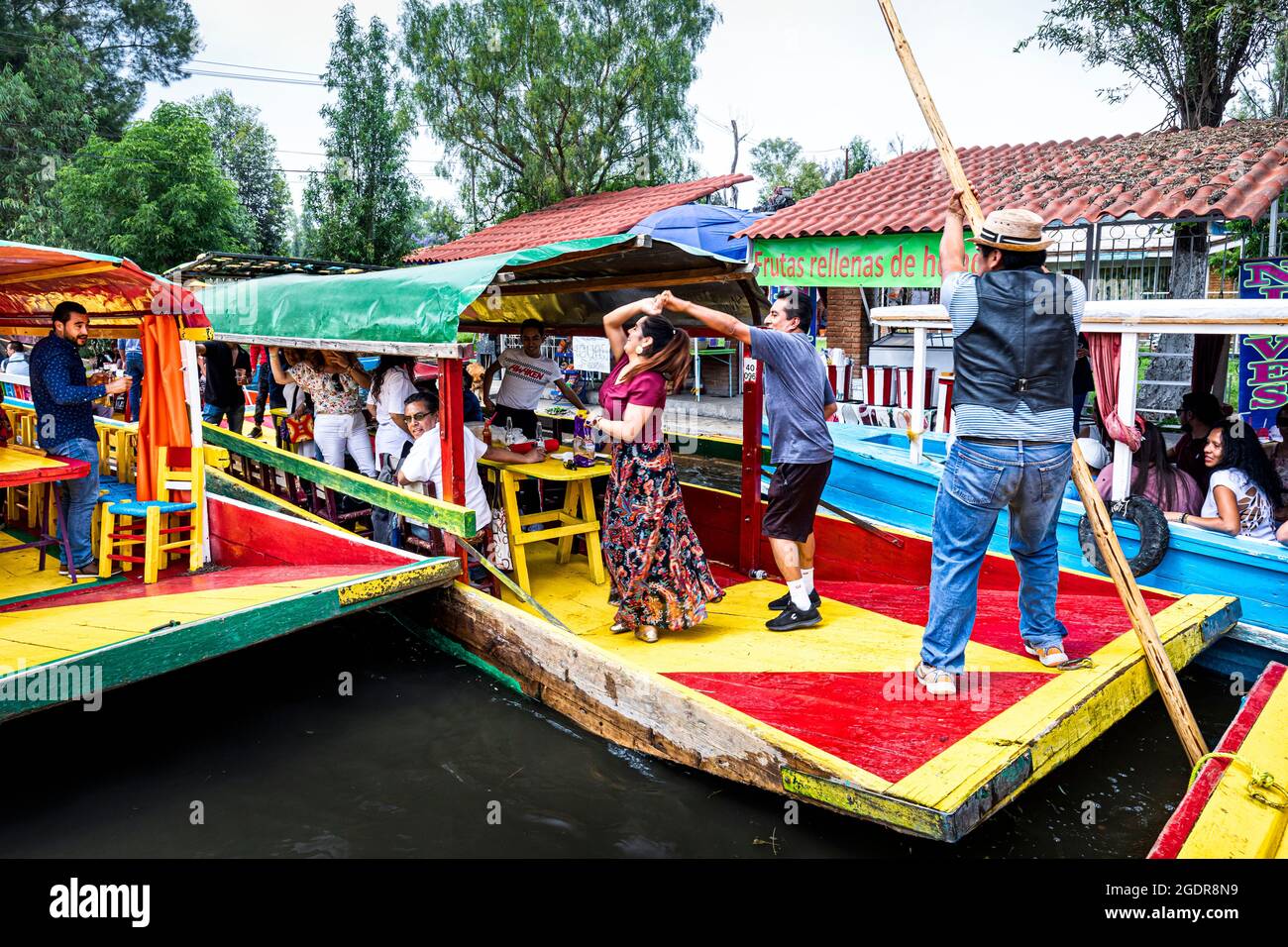 Ein Paar tanzt spontan auf einem der Boote in Xochimilco, Mexiko-Stadt, Mexiko. Stockfoto