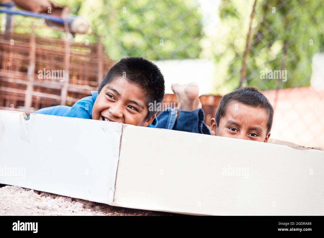 Zwei Jungen spielen in einer leeren Box im Dorf Coatlan, Oaxaca, Mexiko. Stockfoto