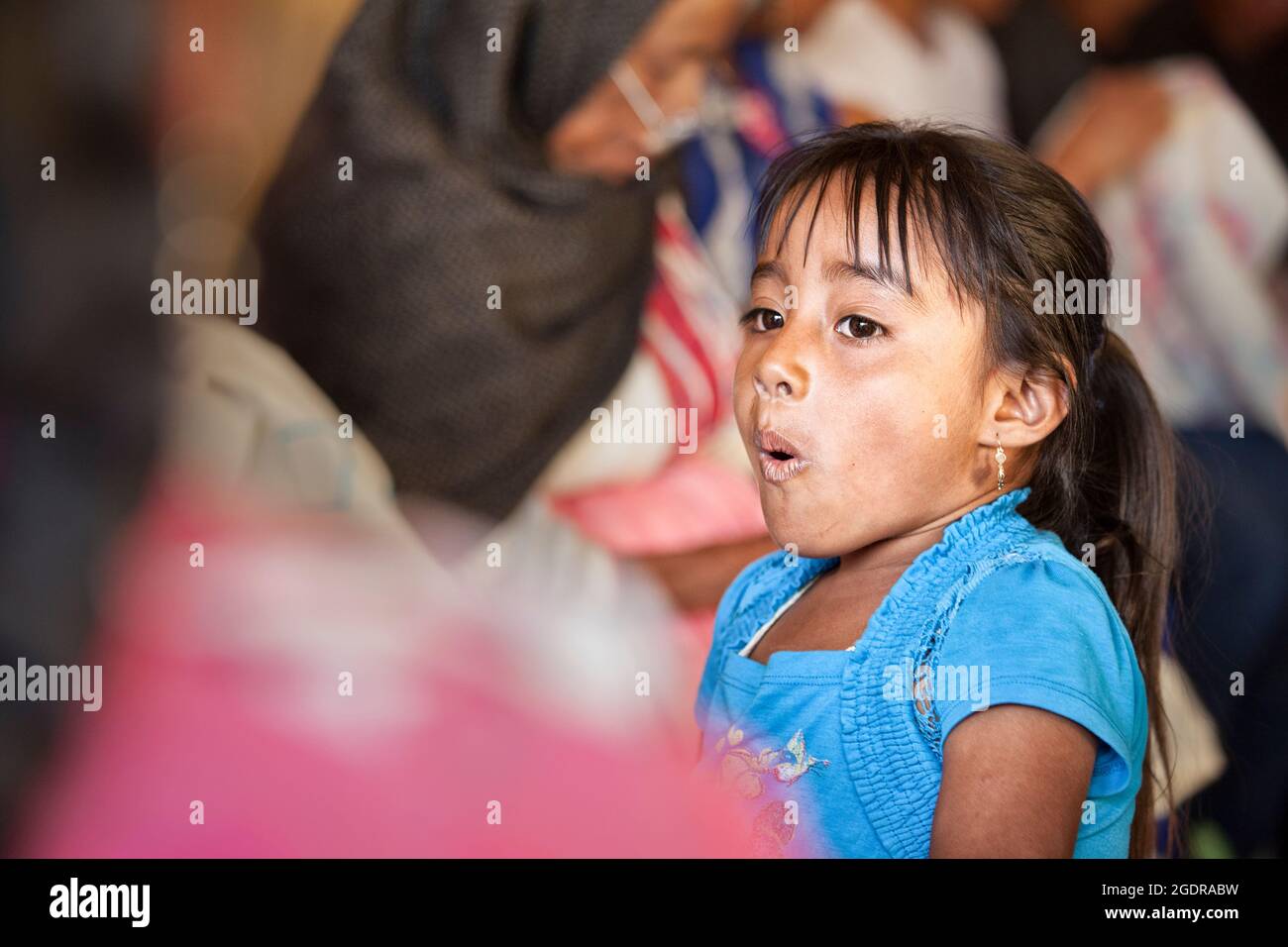 Das kleine Mädchen reagiert auf einen Zaubertrick im Dorf Coatlan, Oaxaca, Mexiko. Stockfoto