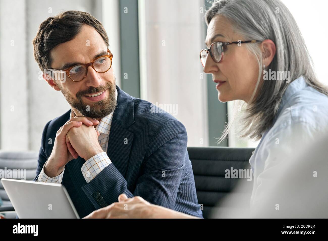 Der männlich lächelnde Manager hört den weiblichen ceo-Mentorinnen im Büro zu. Stockfoto