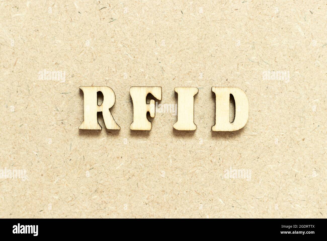 Buchstabenbuchstabe im Wort RFID (Abkürzung für Radio-frequency identification) auf Holzhintergrund Stockfoto