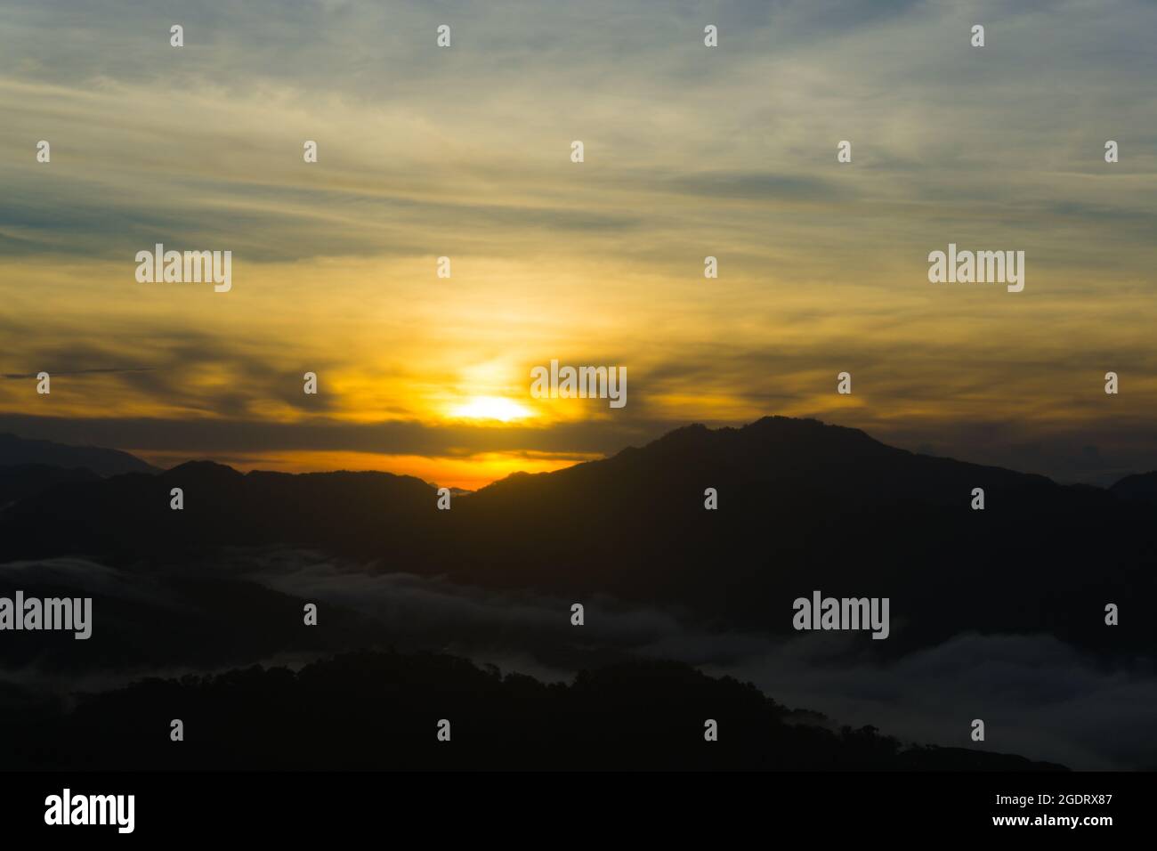 Malerischer Blick auf einen Sonnenaufgang über der nebligen Bergkette Stockfoto