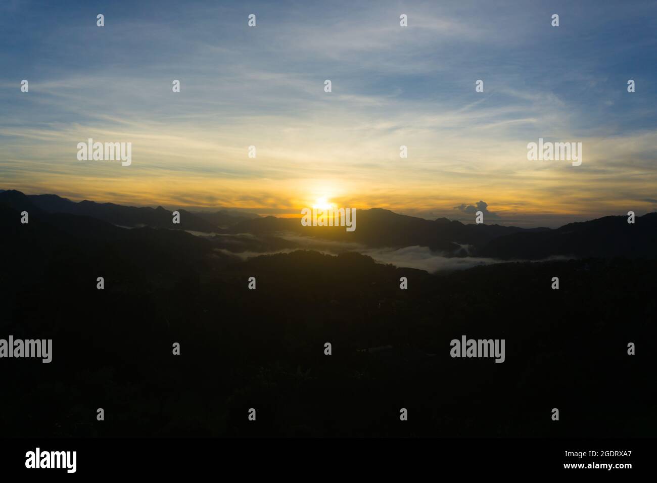 Malerischer Blick auf einen Sonnenaufgang über der nebligen Bergkette Stockfoto