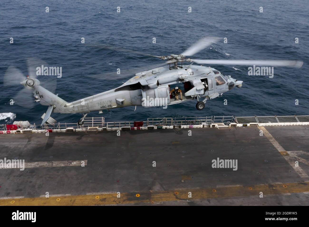 210813-N-WP865-1023 GOLF VON OMAN (AUG 13, 2021) ein Hubschrauber der MH-60S Sea Hawk, der den „Chargers“ des Helicopter Sea Combat Squadron (HSC) 26 zugewiesen wurde, bereitet sich auf die Landung an Bord des amphibischen Sturmschiffs USS Iwo Jima (LHD 7) der Wasp-Klasse vor, der am 13. August auf dem Schiff landet. Iwo Jima IS wird im Einsatzgebiet der 5. US-Flotte eingesetzt, um die maritime Stabilität und Sicherheit in der Zentralregion zu gewährleisten und das Mittelmeer und den Pazifik durch den westlichen Indischen Ozean und drei strategische Engpässe zu verbinden. (USA Navy Foto von Mass Communication Specialist 2nd Class Brenton Poyser) Stockfoto