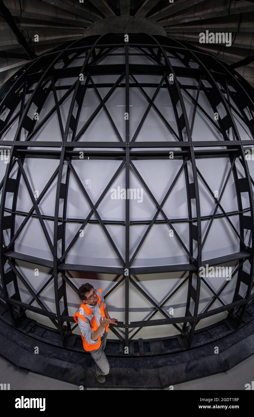 11. August 2021, Sachsen-Anhalt, Halle (Saale): Vor der Sternenkuppel im zukünftigen Planetarium in Halle/Saale steht Dirk Schlesier, Direktor des Planetariums. Die Konstruktion wird eines der modernsten Planetarien in Deutschland schaffen. Die Kuppel wurde zuletzt installiert. Er besteht aus 144 Aluminiumsegmenten und misst an seiner Basis zwölf Meter im Durchmesser. Die sechs Tonnen schwere Kuppel wurde in Ohio, USA, hergestellt und befindet sich im Herzen des Planetariums. Rund 100 Zuschauer sollen ab Frühjahr 2022 unter dem Firmament sitzen und den Nachthimmel betrachten können. In der Zwischenzeit die Baukosten Stockfoto
