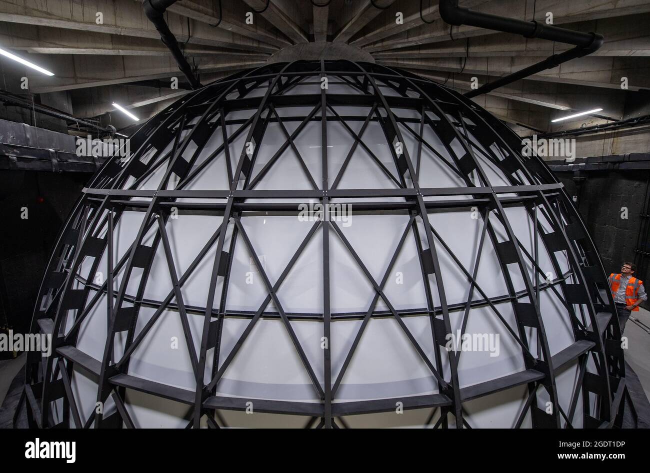 11. August 2021, Sachsen-Anhalt, Halle (Saale): Vor der Sternenkuppel im zukünftigen Planetarium in Halle/Saale steht Dirk Schlesier, Direktor des Planetariums. Die Konstruktion wird eines der modernsten Planetarien in Deutschland schaffen. Die Kuppel wurde zuletzt installiert. Er besteht aus 144 Aluminiumsegmenten und misst an seiner Basis zwölf Meter im Durchmesser. Die sechs Tonnen schwere Kuppel wurde in Ohio, USA, hergestellt und befindet sich im Herzen des Planetariums. Rund 100 Zuschauer sollen ab Frühjahr 2022 unter dem Firmament sitzen und den Nachthimmel betrachten können. In der Zwischenzeit die Baukosten Stockfoto