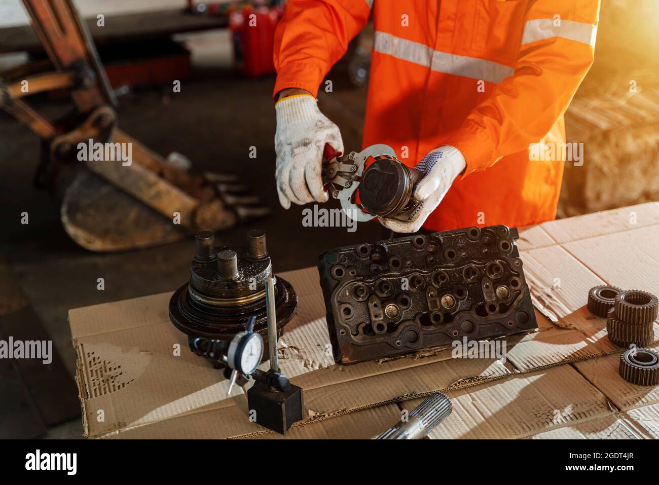 Nahaufnahme der Hand des Technikers, der den Kolben der Hydraulikpumpe hält, um schwere Maschinen zu inspizieren und zu reparieren, Industrial Theme. Stockfoto