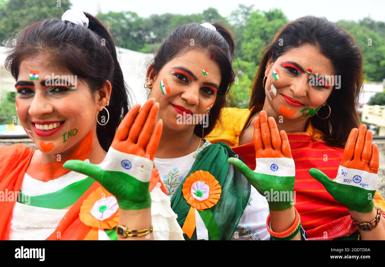 Indische Frauen malen ihre Gesichter mit sozialen Botschaften und den Farben des Nationaltrikolors während des Unabhängigkeitstages in Jabalpur. Stockfoto