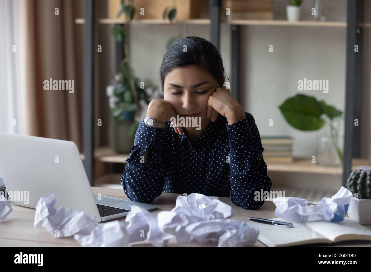 Müde indische Frau schlafen am Arbeitsplatz ein Stockfoto