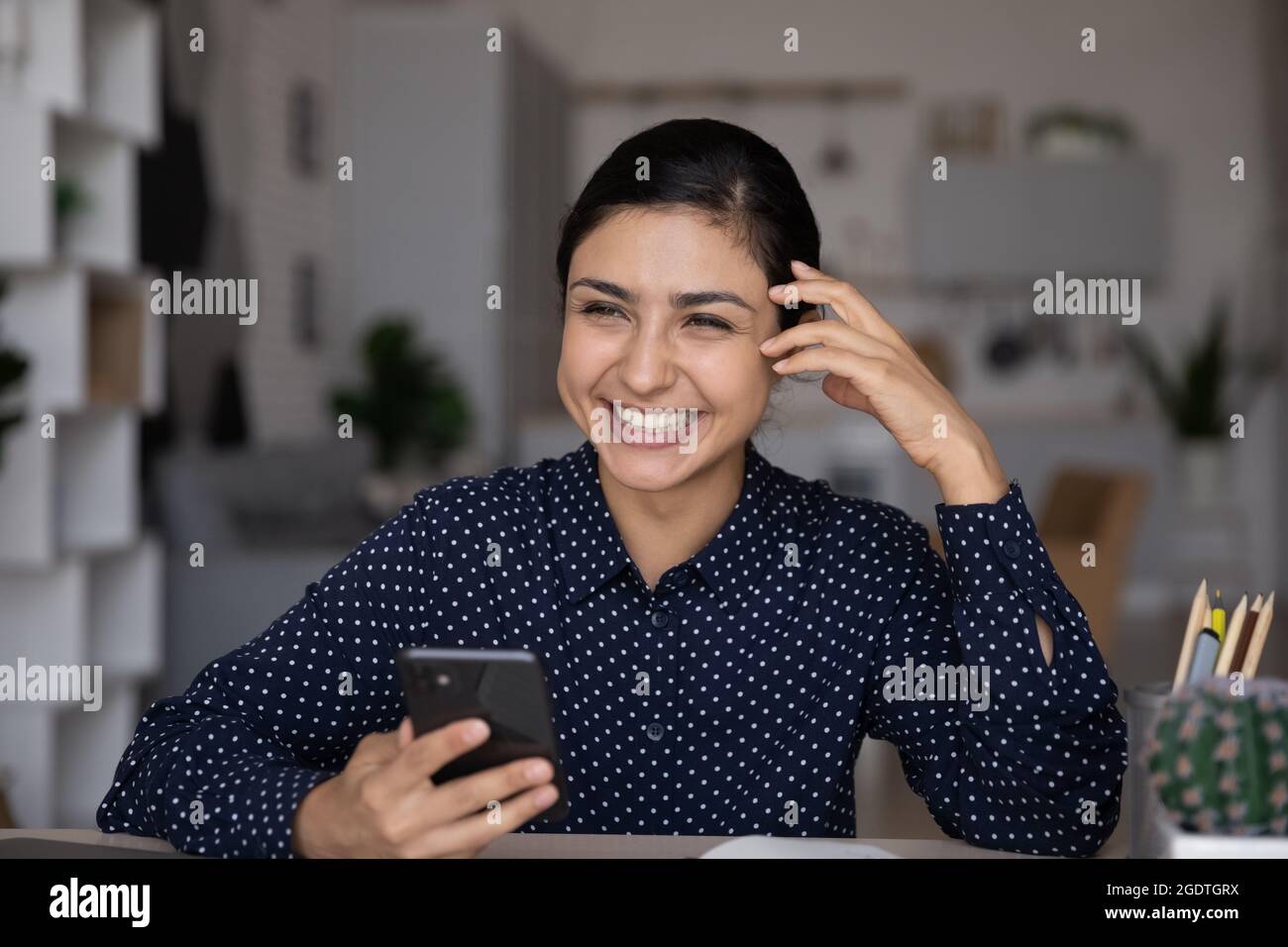 Glückliche indische Frau verwenden Handy im Web surfen Stockfoto