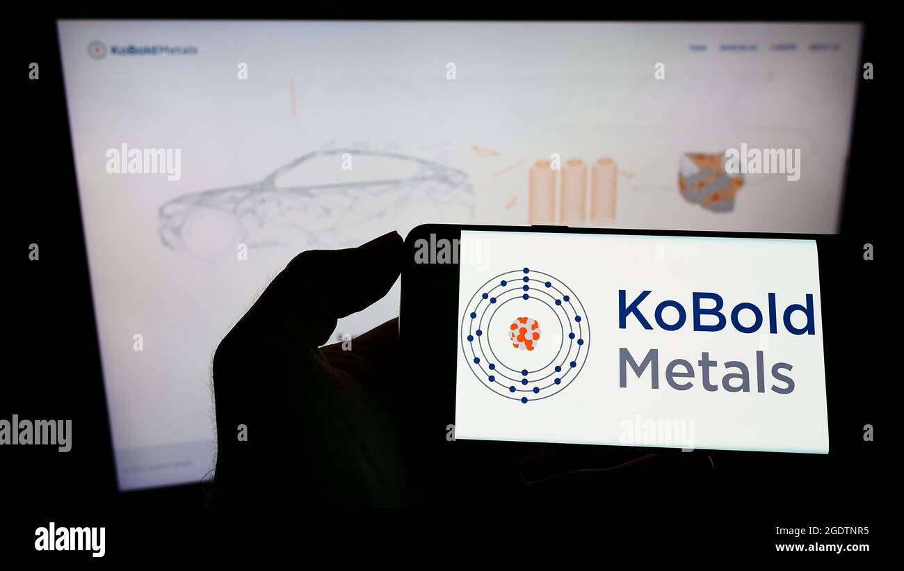 Person mit Mobiltelefon und Logo des amerikanischen Bergbautechnikunternehmens Kobold Metals auf dem Bildschirm vor der Webseite. Konzentrieren Sie sich auf die Telefonanzeige. Stockfoto