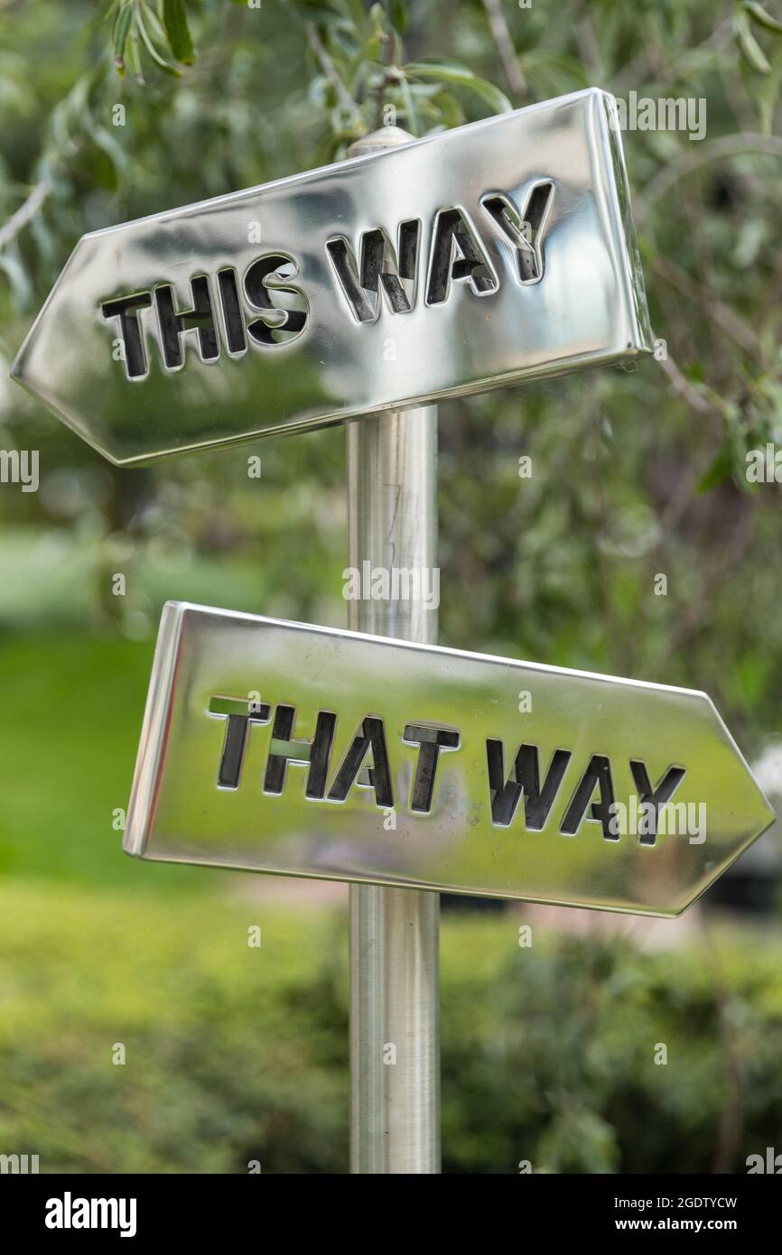 Silberne Pfeilschilder in entgegengesetzte Richtungen Stockfoto