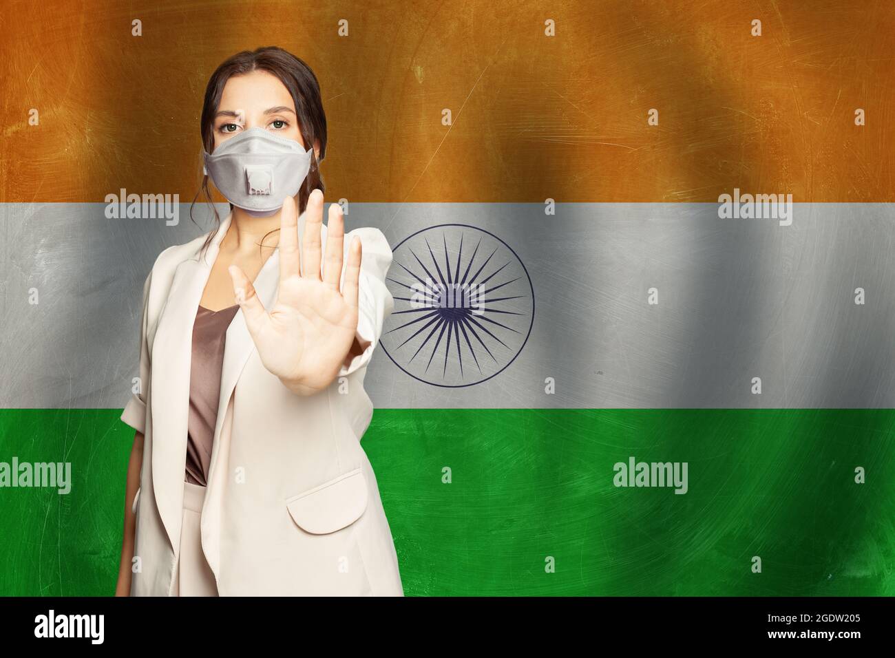 Indische Frau in Anti-Virus-Schutzmaske zeigt Stop-Geste auf indischer Flagge Hintergrund. Prävention von Coronavirus COVID-19 und SARS COV 2 und Coron Stockfoto