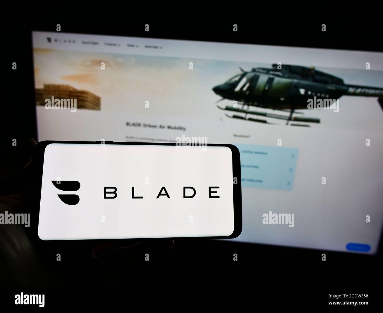 Person mit Mobiltelefon und Logo des US-Transportunternehmens BLADE Urban Air Mobility Inc. Auf dem Bildschirm vor der Webseite. Konzentrieren Sie sich auf die Telefonanzeige. Stockfoto