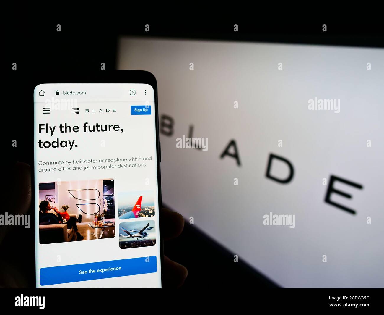 Person mit Mobiltelefon und Website des US-Transportunternehmens BLADE Urban Air Mobility Inc. Auf dem Bildschirm mit Logo. Konzentrieren Sie sich auf die Mitte des Telefondisplays. Stockfoto