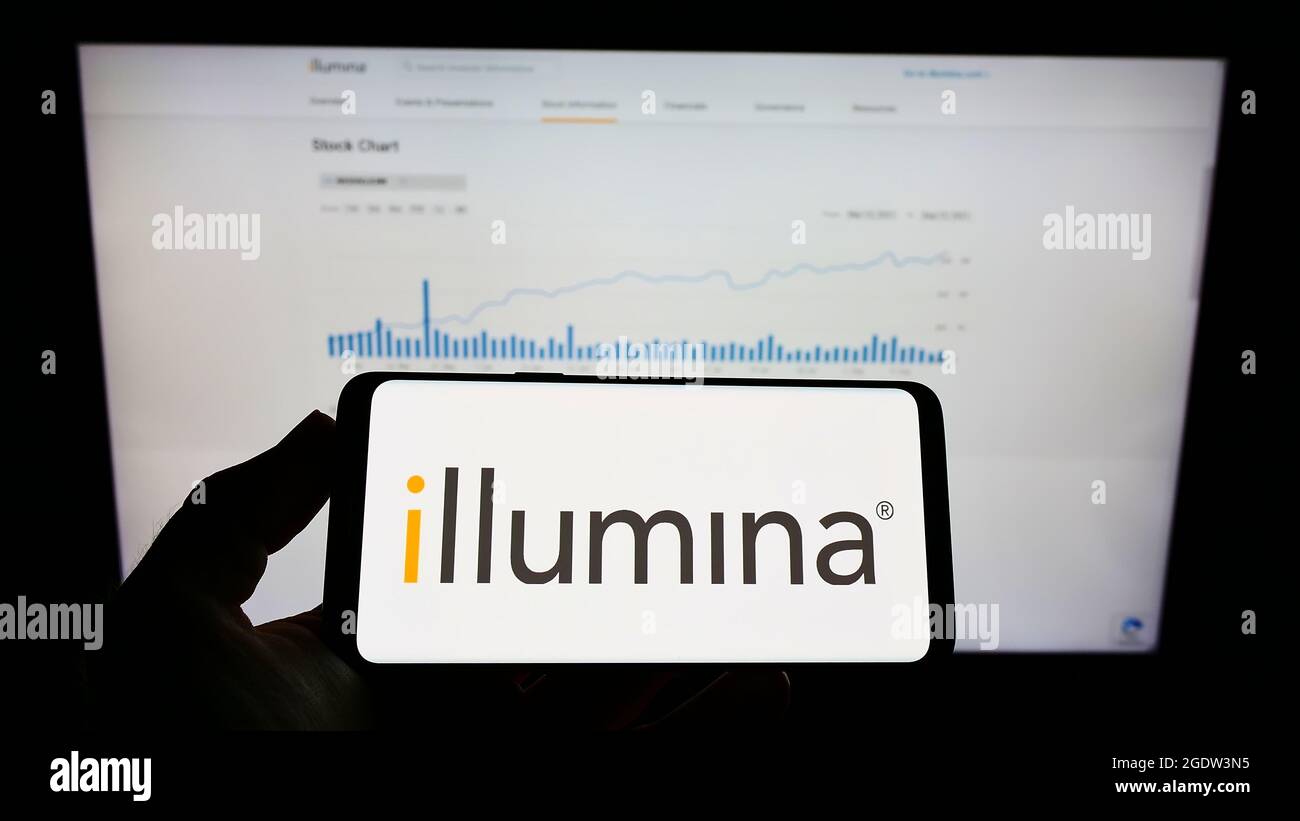 Person, die Mobiltelefon mit dem Logo des US-amerikanischen Genetikunternehmens Illumina Inc. Auf dem Bildschirm vor der Business-Webseite hält. Konzentrieren Sie sich auf die Telefonanzeige. Stockfoto
