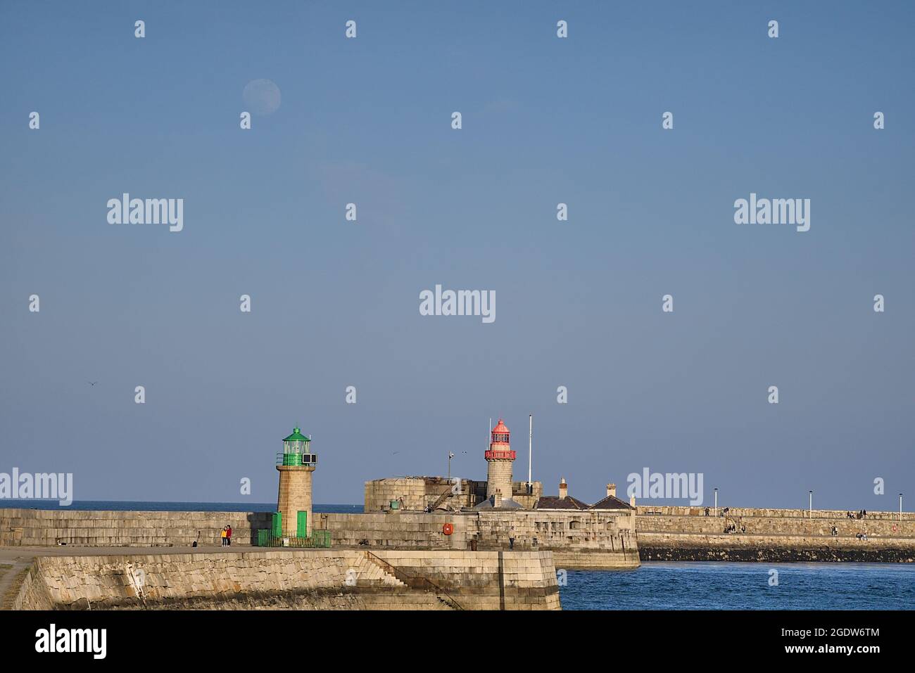 Wunderschöne Abendansicht der roten und grünen Leuchttürme am East und West Pier und des aufgehenden Mondes im Hafen von Dun Laoghaire, Dublin. Irland, weich und selektiv Stockfoto