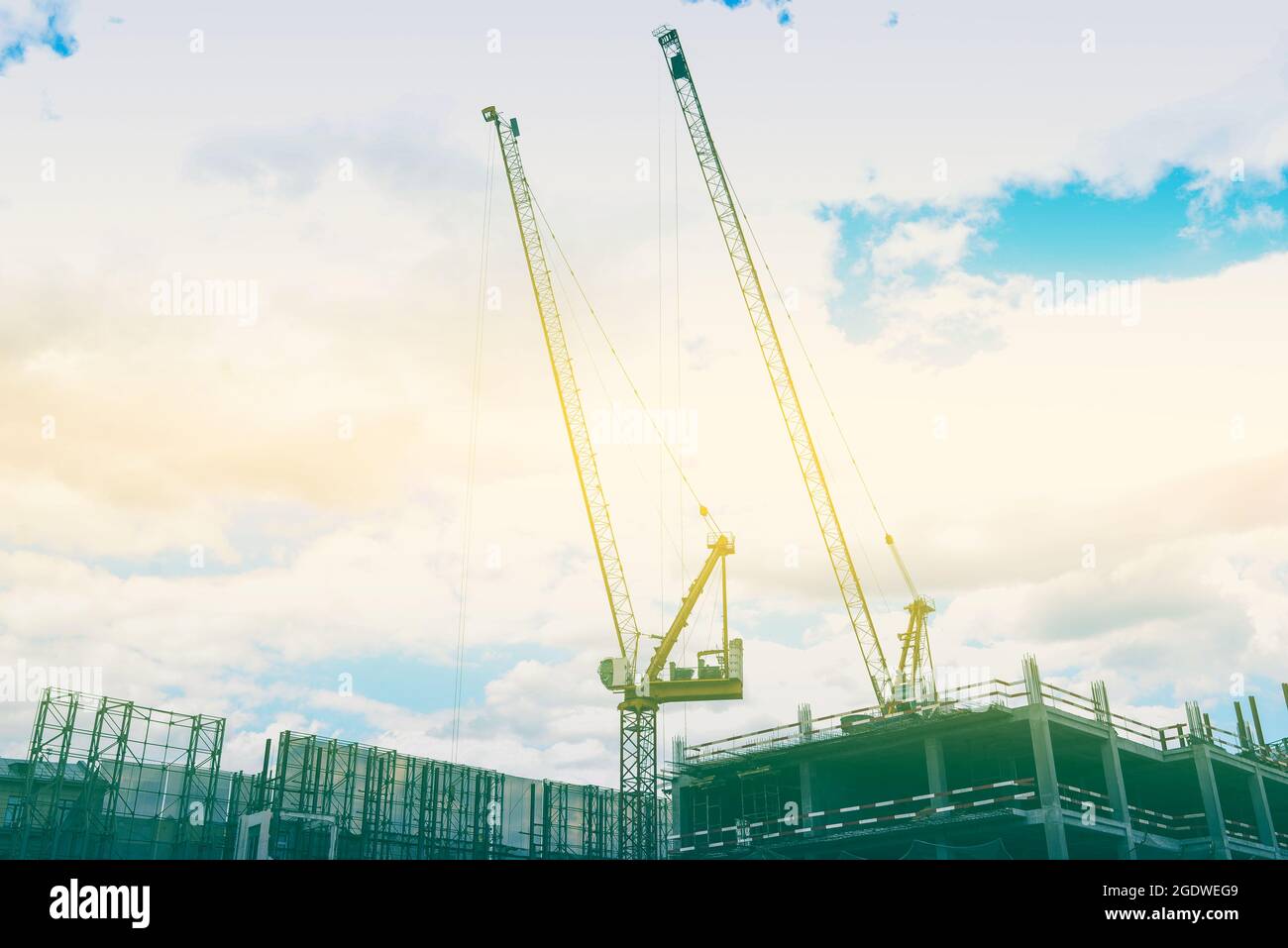 Bau von Häusern. Baustelle und gelber Turmdrehkran. Bau neuer mehrstöckiger Wohngebäude. Das Konzept des Kaufs echter E Stockfoto