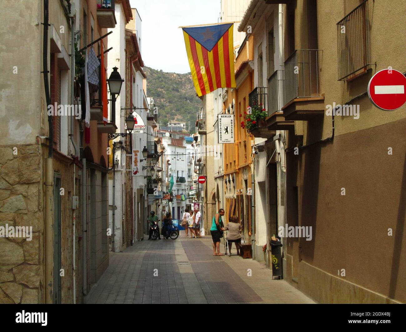 TOSSA DE MAR, SPANIEN - 24. Aug 2013: Eine schmale Straße mit katalanischer Flagge, in der Küstenstadt Tossa de Mar, Katalonien, Spanien Stockfoto