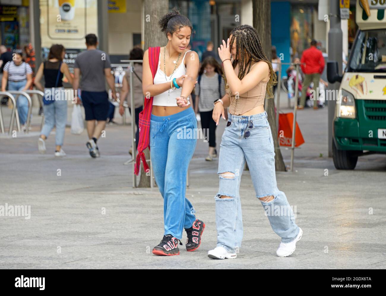 Zwei Mädchen mit gemischter Rasse, die laufen, im Gespräch. Stockfoto