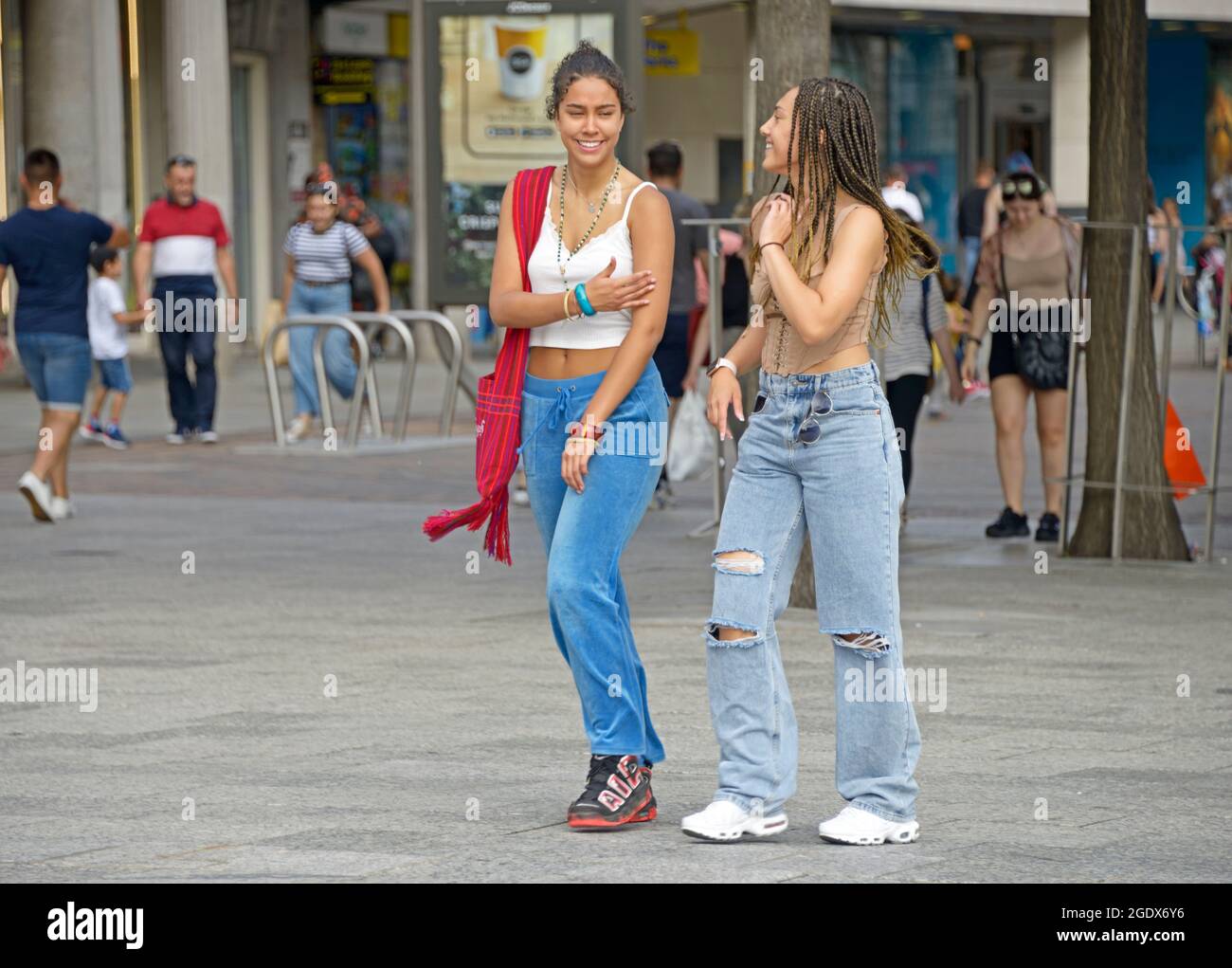 Zwei Mädchen mit gemischter Rasse, die laufen, im Gespräch. Stockfoto